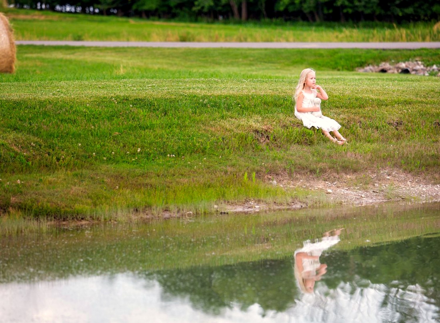A figure near a pond with a reflection